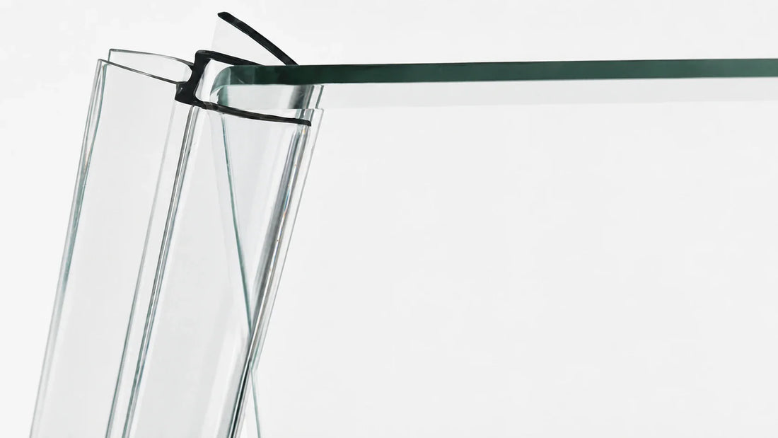 Clear clip-on shower door seal gripping the edge of the glass without glue