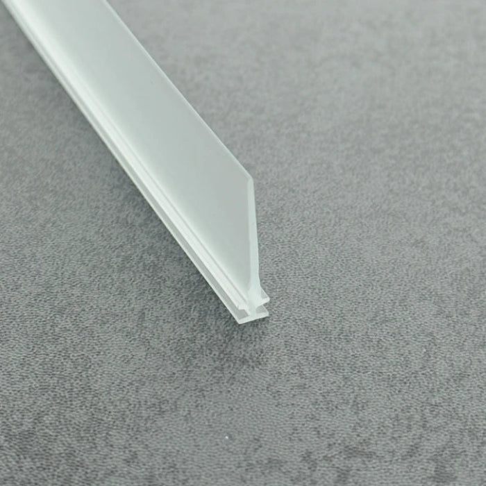 High-clarity close-up of a clear vinyl framed shower door drip sweep, showcasing the high light transmission, smooth vinyl texture, and exceptional flexibility of the VI001's 28mm long fin, highlighting its resistance to cracking when bent to effectively conform to various complex floor profiles while maintaining visual transparency.