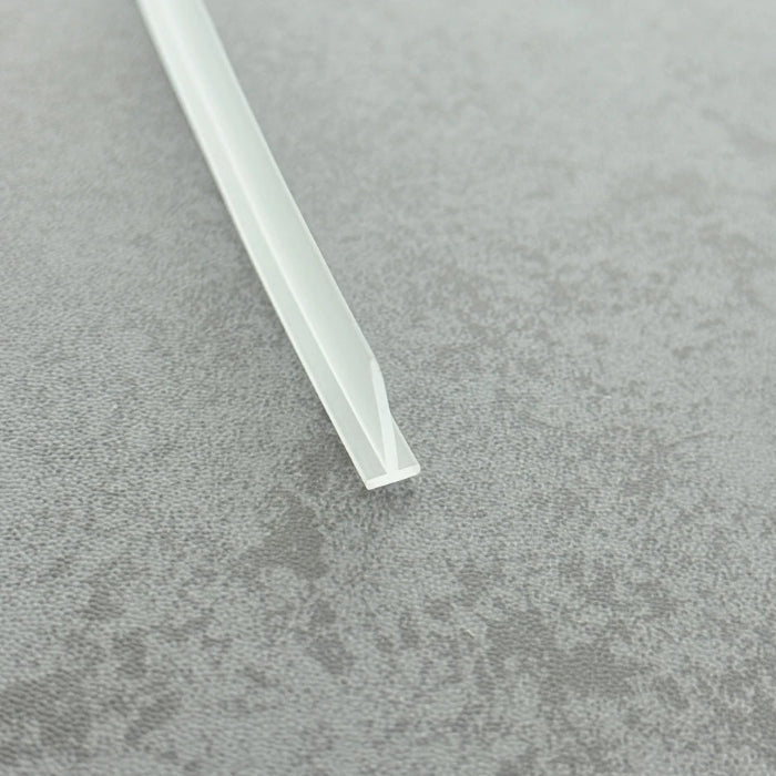 Micro-view of a clear t-bar seal strip for framed doors, showing how the 6mm T-head achieves a tight interference fit within extra-wide grooves to prevent loosening from frequent door operation, while the 15mm long soft fin makes moderate contact with the floor, providing a lasting waterproof barrier at the base of heavy framed doors.