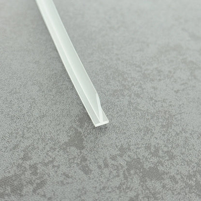 Micro-view of a clear t-bar seal strip for framed doors, showing how the 6mm T-head achieves a tight interference fit within extra-wide grooves to prevent loosening from frequent door operation, while the 15mm long soft fin makes moderate contact with the floor, providing a lasting waterproof barrier at the base of heavy framed doors.