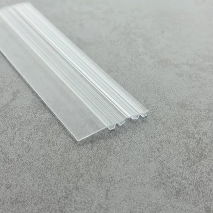 DOU03 clear folding shower door seal showing the extended rigid water-deflector wing