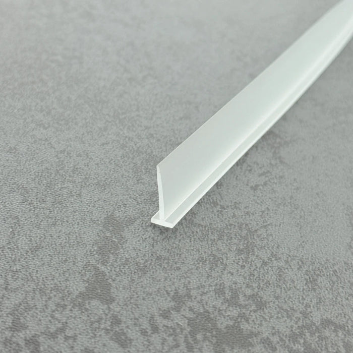 High-clarity close-up of a framed shower door drip rail (clear version), showcasing the high light transmission, smooth vinyl texture, and exceptional flexibility of the VH002's 15mm fin, highlighting its resistance to ageing as an effective substitute for yellowed or hardened old rails to maintain efficient drainage while remaining virtually invisible beneath glass doors.