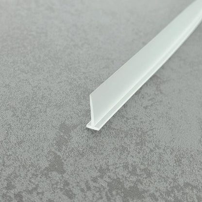 High-clarity close-up of a framed shower door drip rail (clear version), showcasing the high light transmission, smooth vinyl texture, and exceptional flexibility of the VH002's 15mm fin, highlighting its resistance to ageing as an effective substitute for yellowed or hardened old rails to maintain efficient drainage while remaining virtually invisible beneath glass doors.
