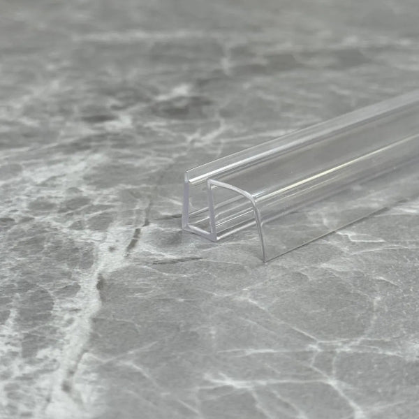 Macro close-up of the S456DTL transparent U-profile, showcasing its high-gloss finish and flexible material quality designed to resist cracking and yellowing in humid UK bathrooms.