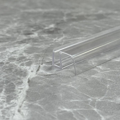 Macro close-up of the S456DTL transparent U-profile, showcasing its high-gloss finish and flexible material quality designed to resist cracking and yellowing in humid UK bathrooms.