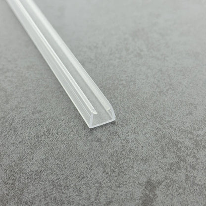 Full view real photo of the UH810 clear U-profile protector on a frameless 10mm shower screen, offering a discreet, high-quality safety finish for luxury bathroom installations.