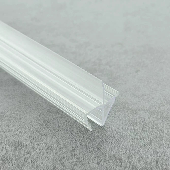 Close-up of the VC456 clear shower door bottom seal showing the rigid clip and offset flexible fin