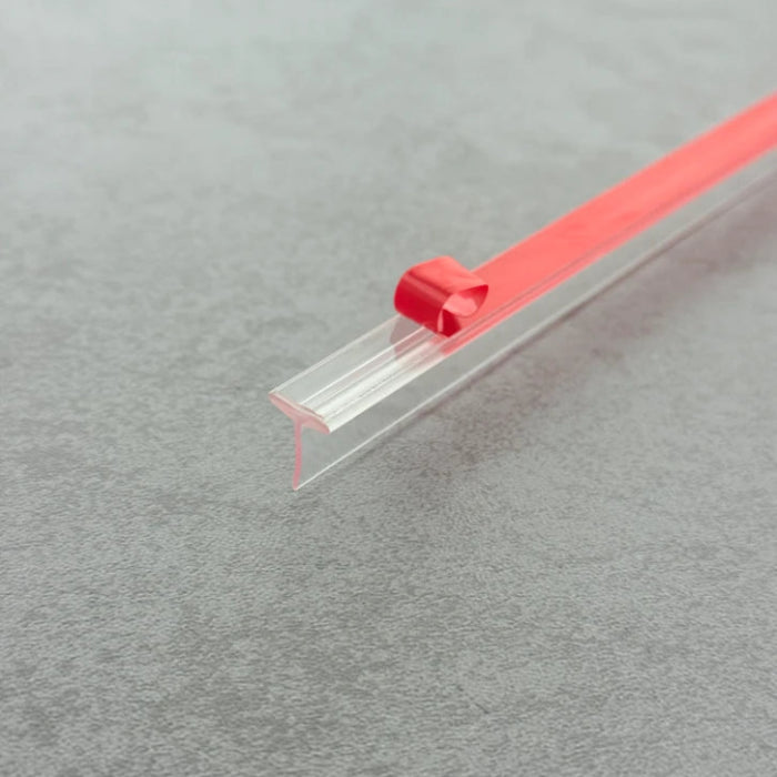 Close-up of the VH009 T-profile shower seal with red peel-off adhesive backing